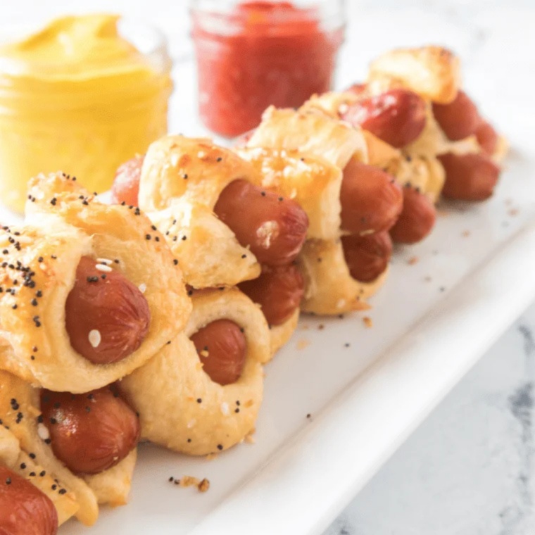 Plate of air fryer bagel dogs served with mustard and ketchup