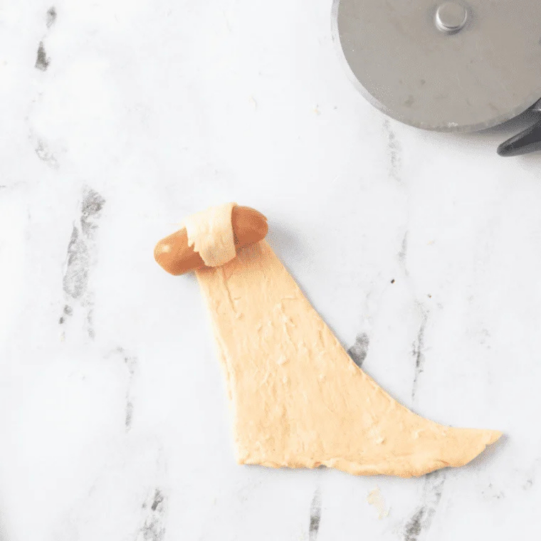 Crescent dough cut into thin half-inch strips for wrapping smokies