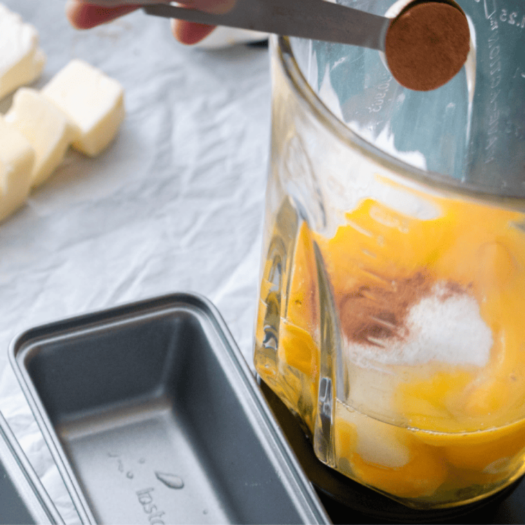 Greased heatproof dish placed next to air fryer, ready for egg loaf batter.