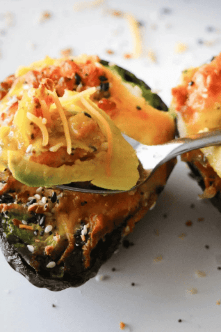 Air Fryer Stuffed Avocado served with a spoon on the side.