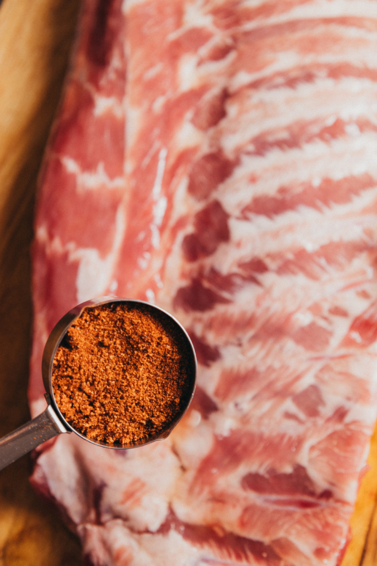 Step-by-step prep of baby back ribs showing membrane removal, homemade dry rub mixing, and seasoning ribs before grilling in Ninja Foodi Grill