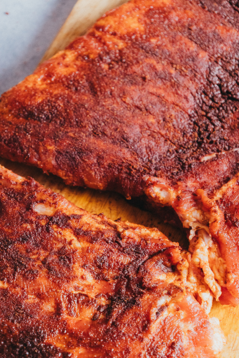Seasoned Ribs on a wooden cutting board.
