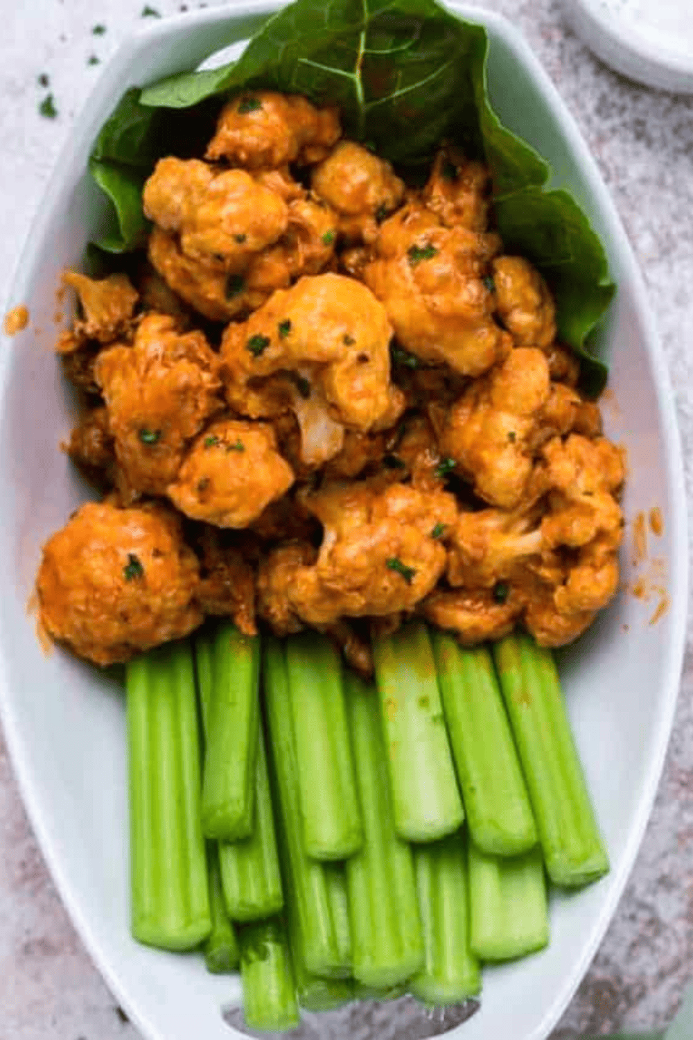 Golden Air Fryer Sweet and Sour Cauliflower served in a bowl, garnished with sesame seeds and green onions.
