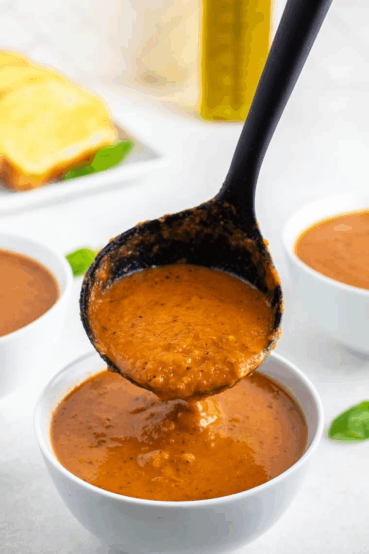 Air Fryer Roasted Tomato Soup served with a side of grilled cheese and garnished with fresh parsley.