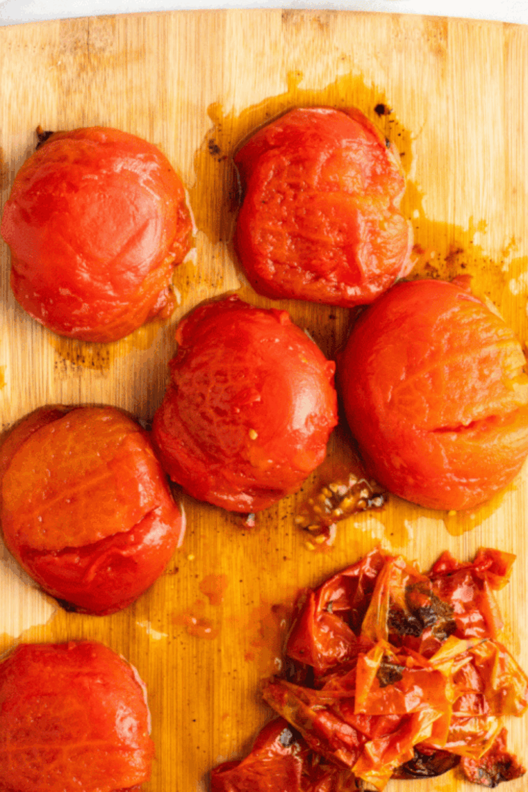 Dicing the roasted tomatoes on a cutting board.