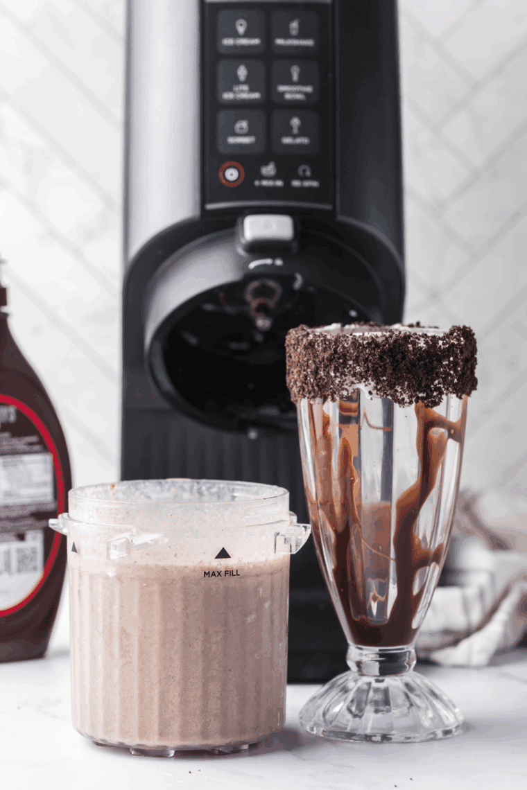 Ninja Creami Oreo Milkshake next to the coated glass.