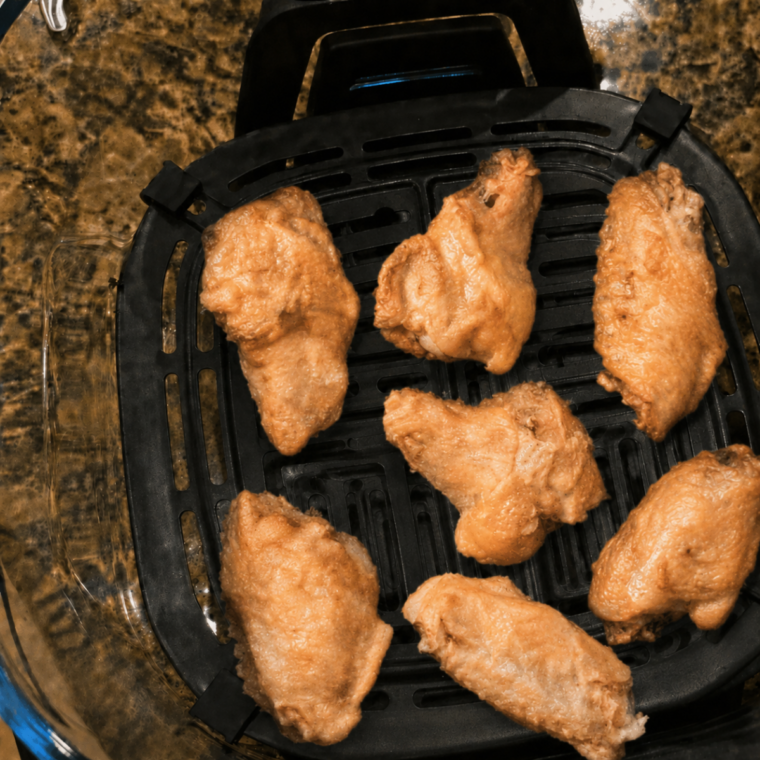 Seasoned chicken wings crisping under the PowerPod, skin starting to brown and blister