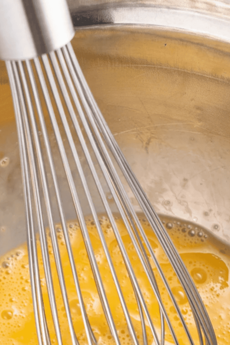 Mixing cream cheese, egg, sweetener, and vanilla in a bowl to make keto cookie dough.