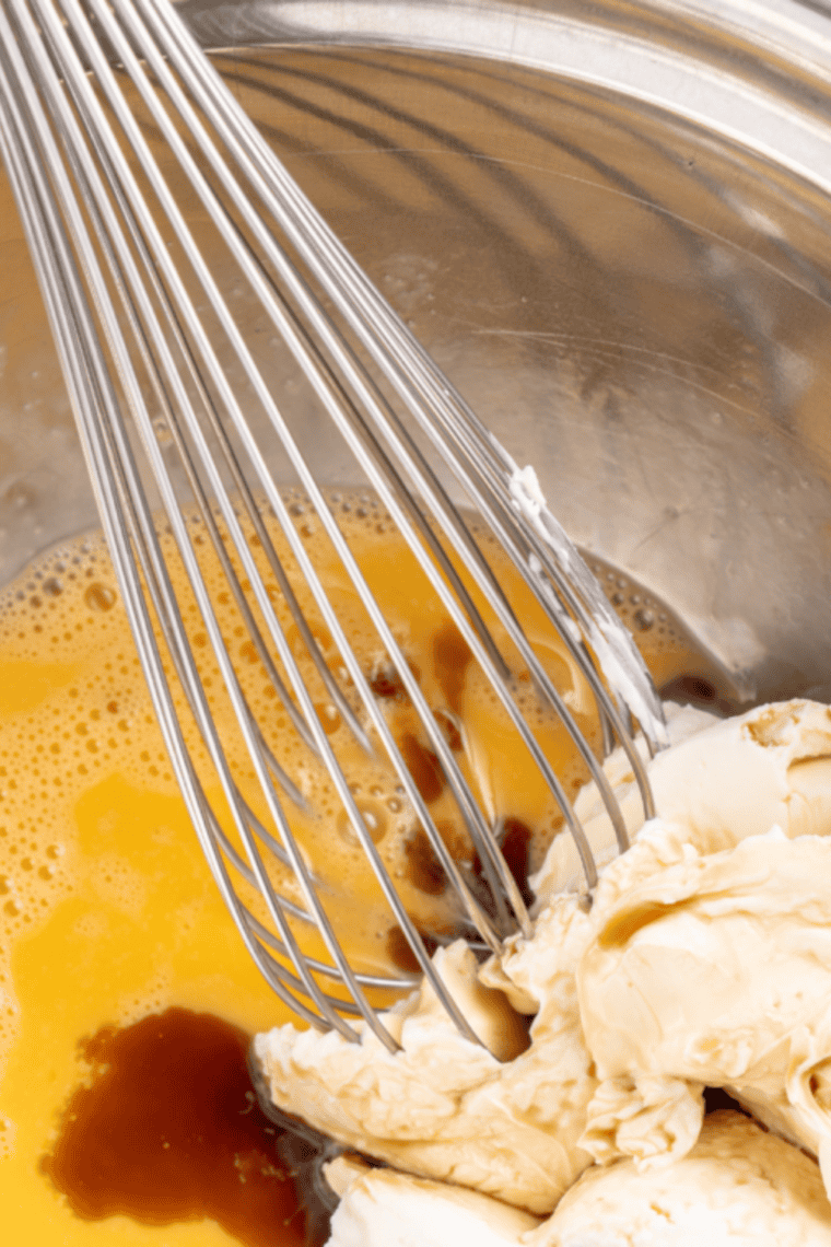 Adding almond flour and baking powder to cream cheese mixture to form firm keto cookie dough.