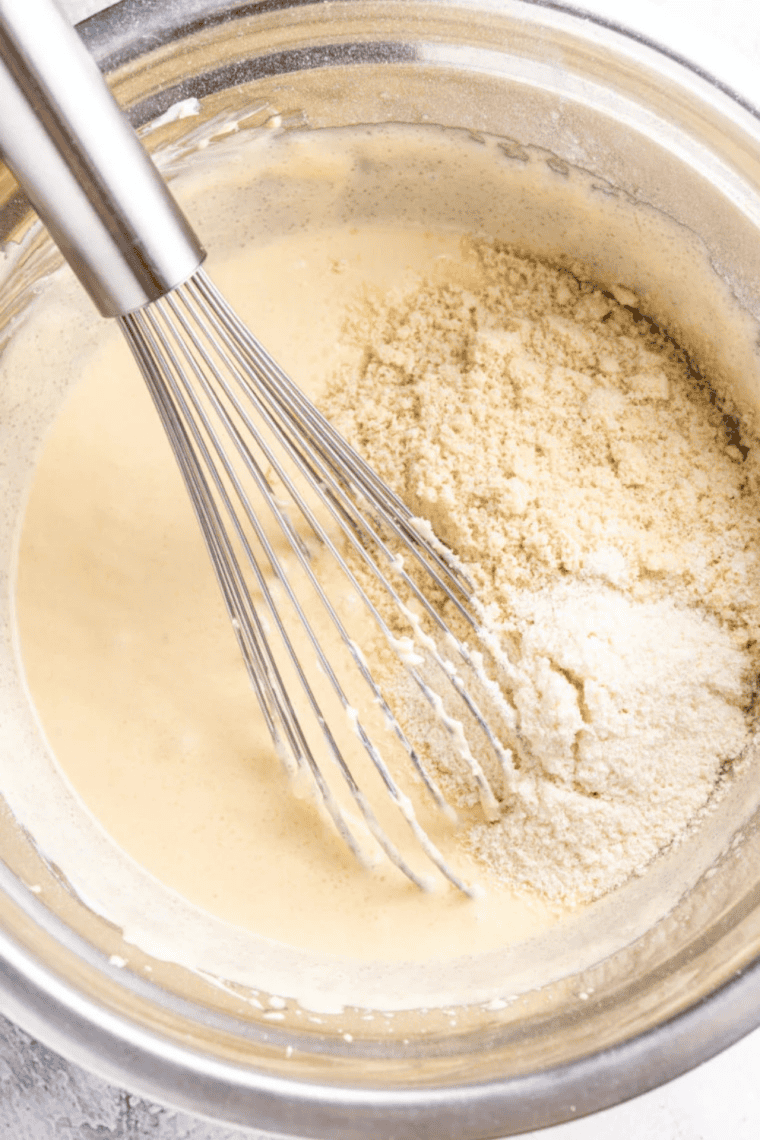 Keto cream cheese cookie dough rolled into balls on a parchment-lined tray.