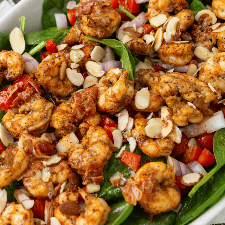 Applebee&rsquo;s-style grilled shrimp spinach salad served on plates with extra bacon and lemon wedges.