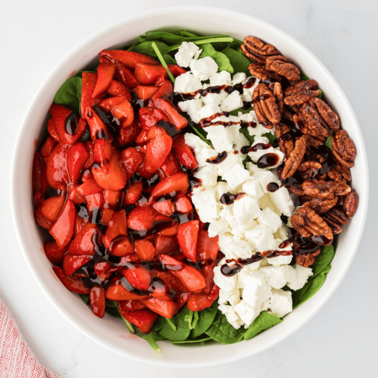 Air fryer strawberry candy sprinkled on top of a fresh green salad