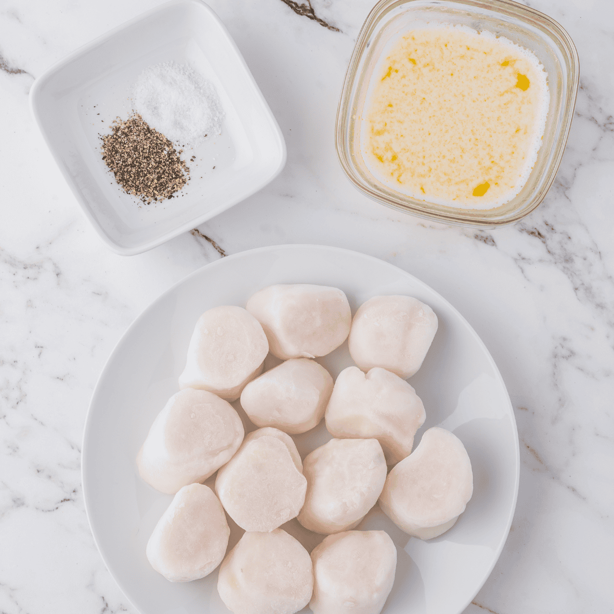 Patting scallops dry and seasoning with olive oil, garlic powder, and sea salt for air frying