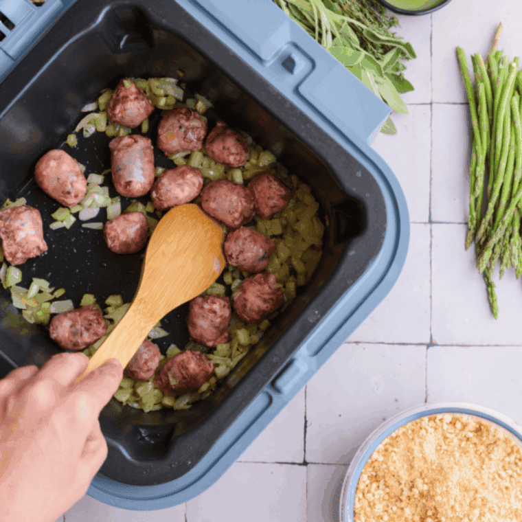 Folding in sage, thyme, diced sausage, bread cubes, cranberries, and chicken broth in the Ninja Speedi for Boston Market-style vegetable stuffing