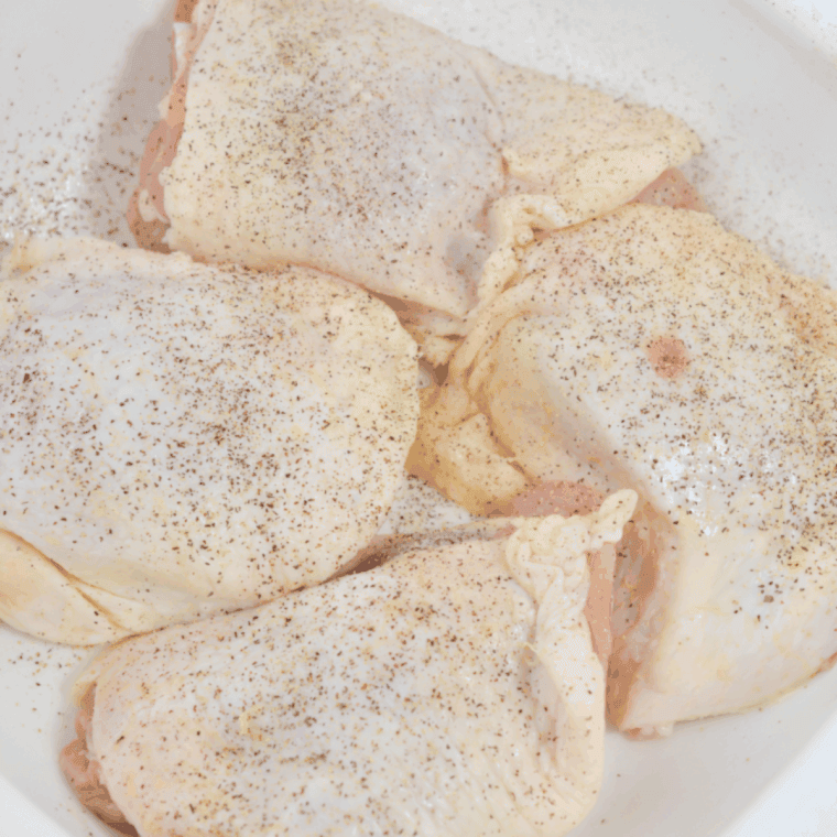 Patting bone-in chicken thighs dry with paper towels