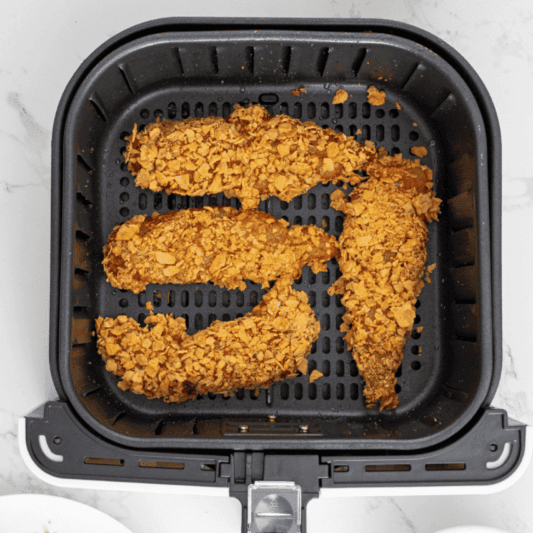Arrange breaded chicken tenders in air fryer basket, cook at 350°F, flipping halfway, until fully cooked to 165°F.