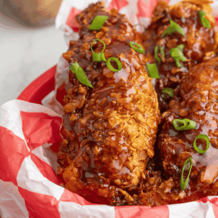 Crispy honey BBQ chicken strips on a plate, ready to serve.