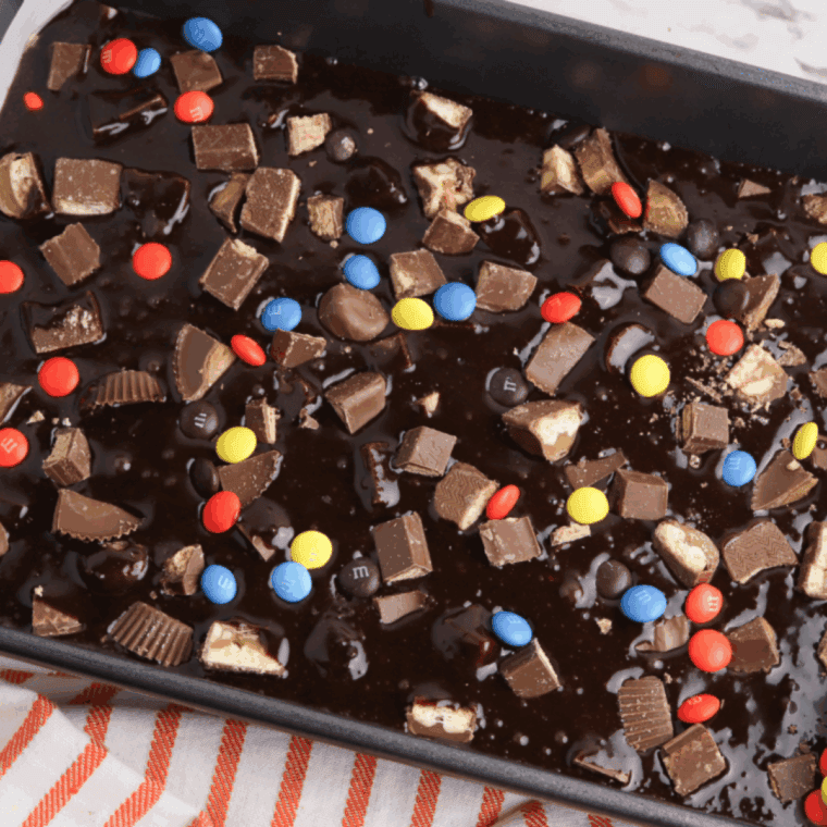 Brownie batter in pan baking in the oven, getting golden and fudgy