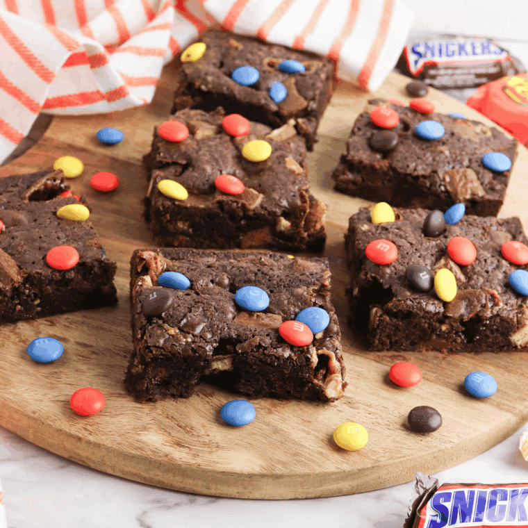 Fudgy brownies filled with chopped leftover Halloween candy, served on a plate