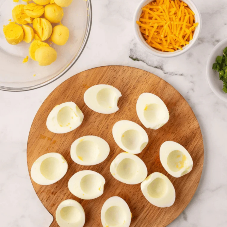 Piping creamy no-mustard filling into egg whites and sprinkling with paprika to finish.