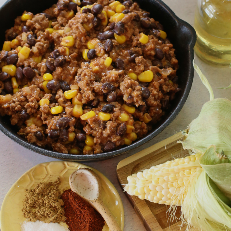 Ground beef with chili powder and cumin browning in an air fryer safe skillet