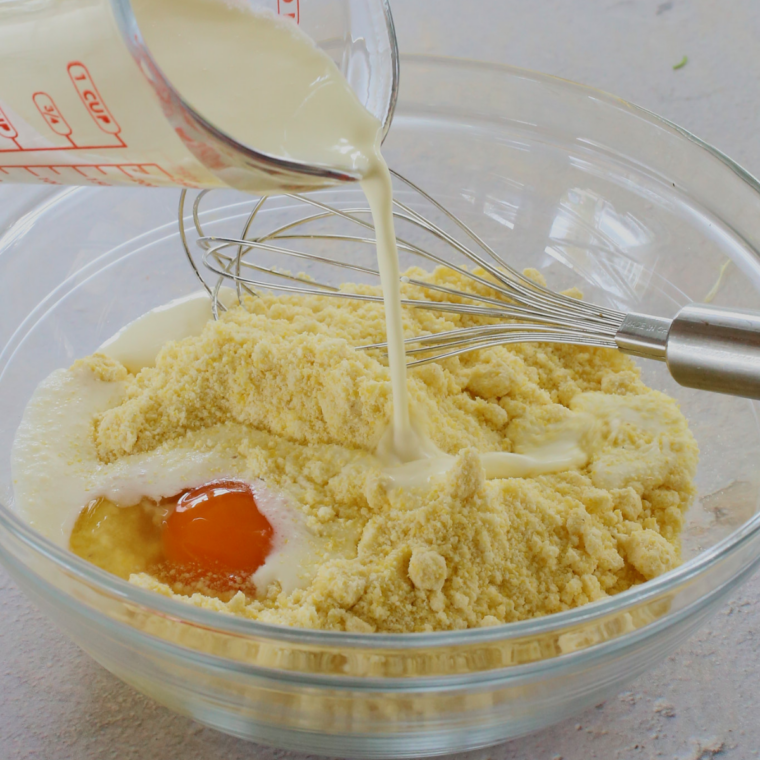Jiffy corn muffin batter whisked in a glass bowl with egg and milk