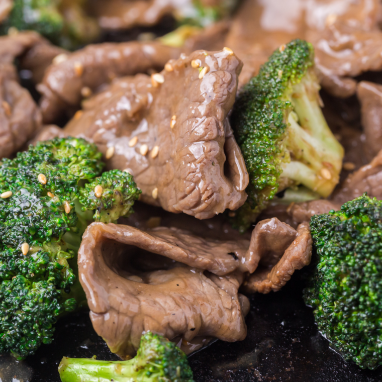 Blackstone broccoli florets sizzling on a hot griddle with crispy charred edges and steam rising