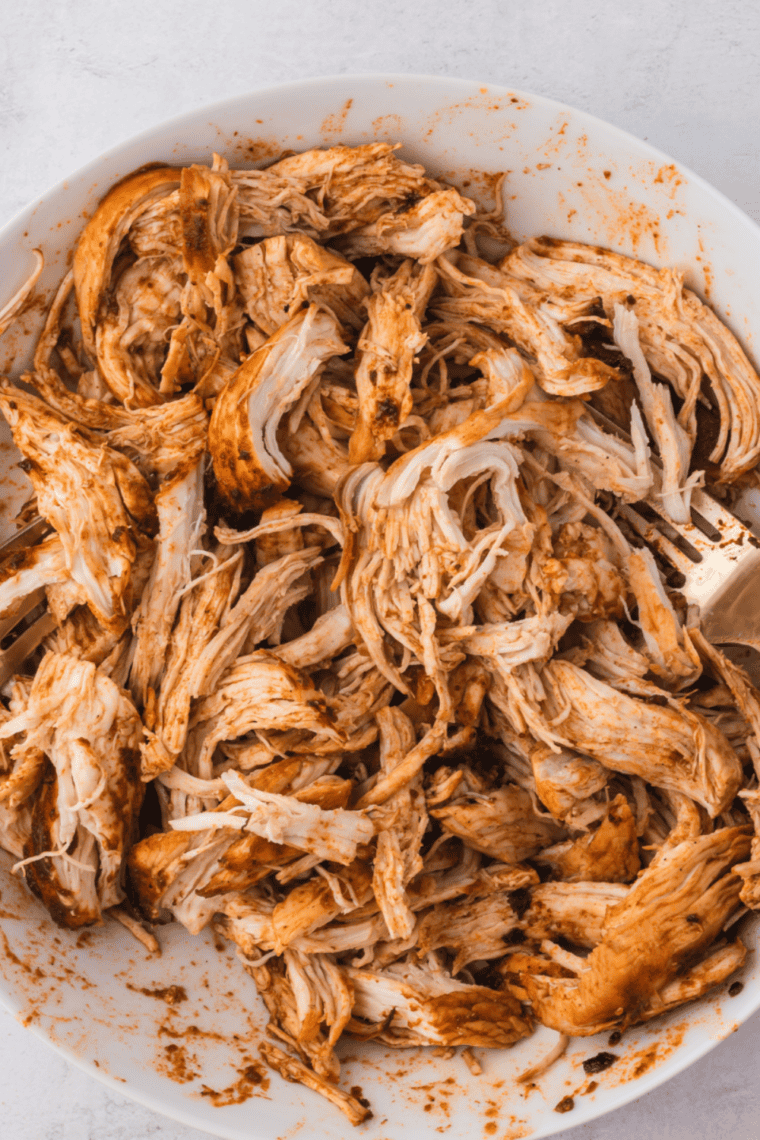 Shredded chicken taco filling in a slow cooker with Rotel and spices.
