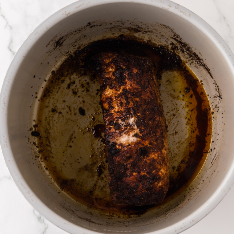 Seasoned pork tenderloin placed in the Ninja Foodi air fryer basket