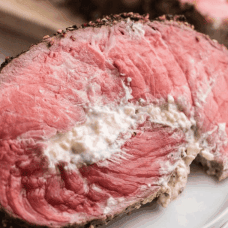 Sliced air fryer blue cheese stuffed flank steak on a plate, showing melty cheese filling