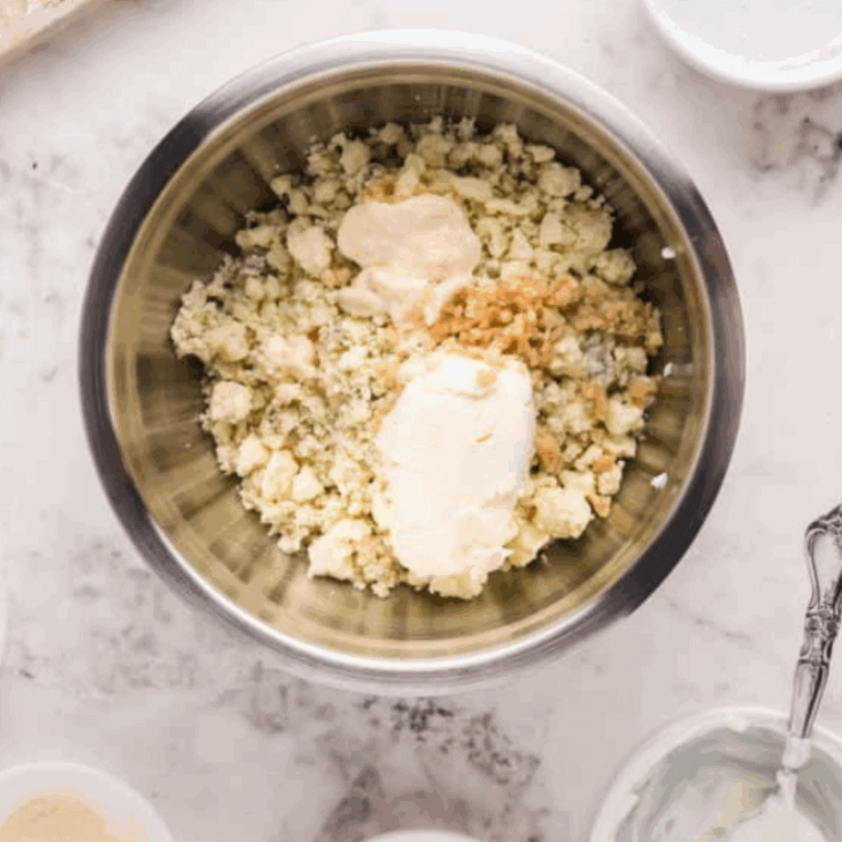 Blue cheese stuffing mixture with garlic, horseradish, sour cream and cream cheese beside salt and cracked pepper in bowl