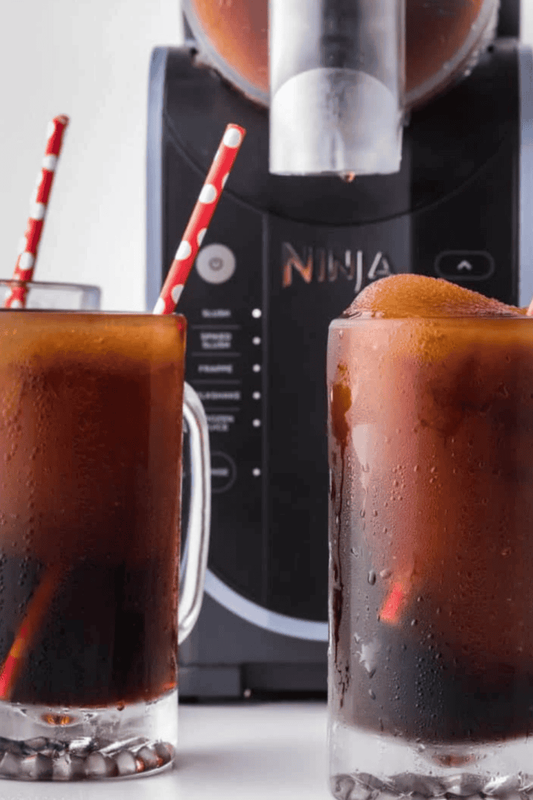 Delicious Ninja Slushi Root Beer Float Slush in a glass with frothy foam, a refreshing and creamy treat.