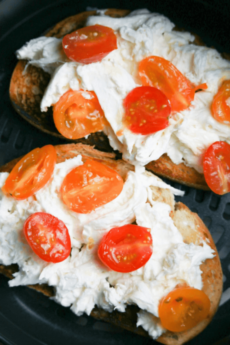 Burrata cheese spread evenly over buttered and olive-oil-coated Italian bread slices