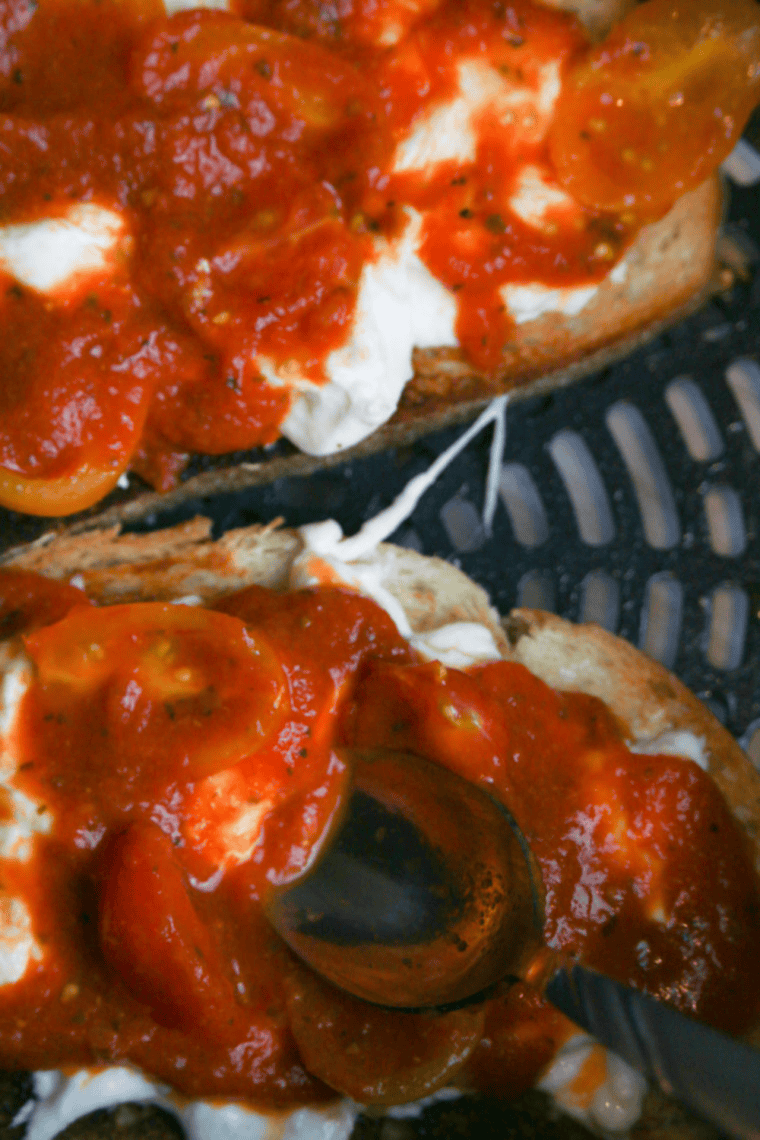 Bread slices with burrata cooking in the air fryer until crispy and melted