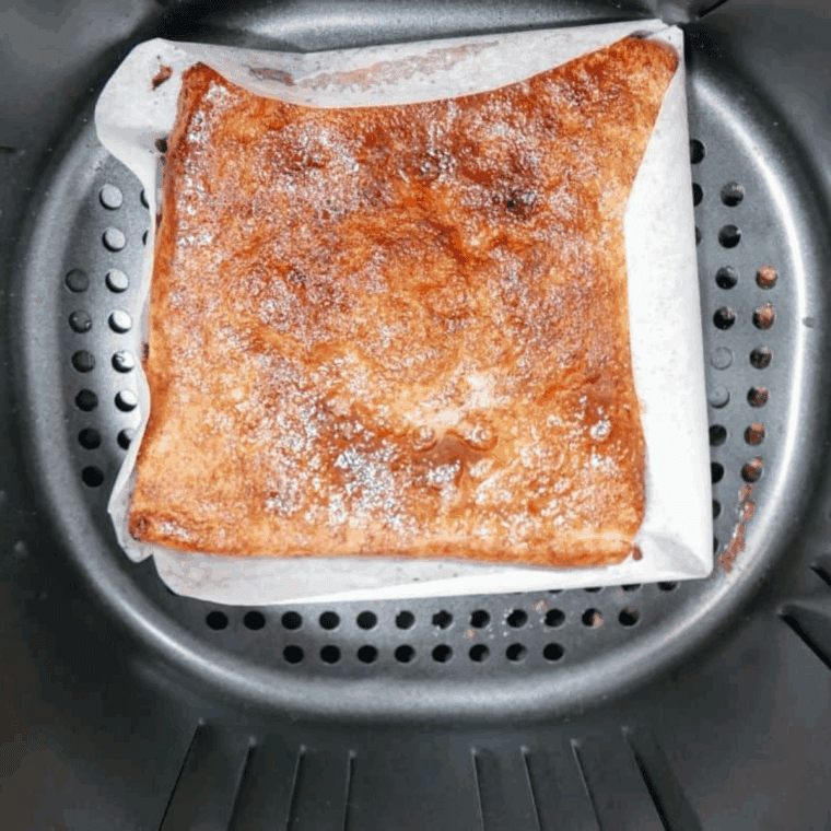 Cooked Copycat Pizza Hut Cinnamon Sticks in the air fryer basket.