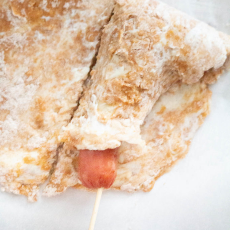 Dough pressed into a flat rectangle between parchment paper and cut into four sections.