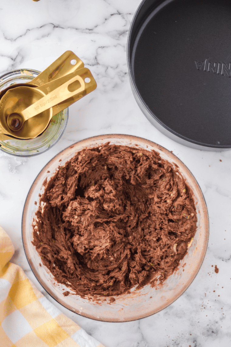 Whisking together flour, baking powder, salt, and cinnamon in a mixing bowl.