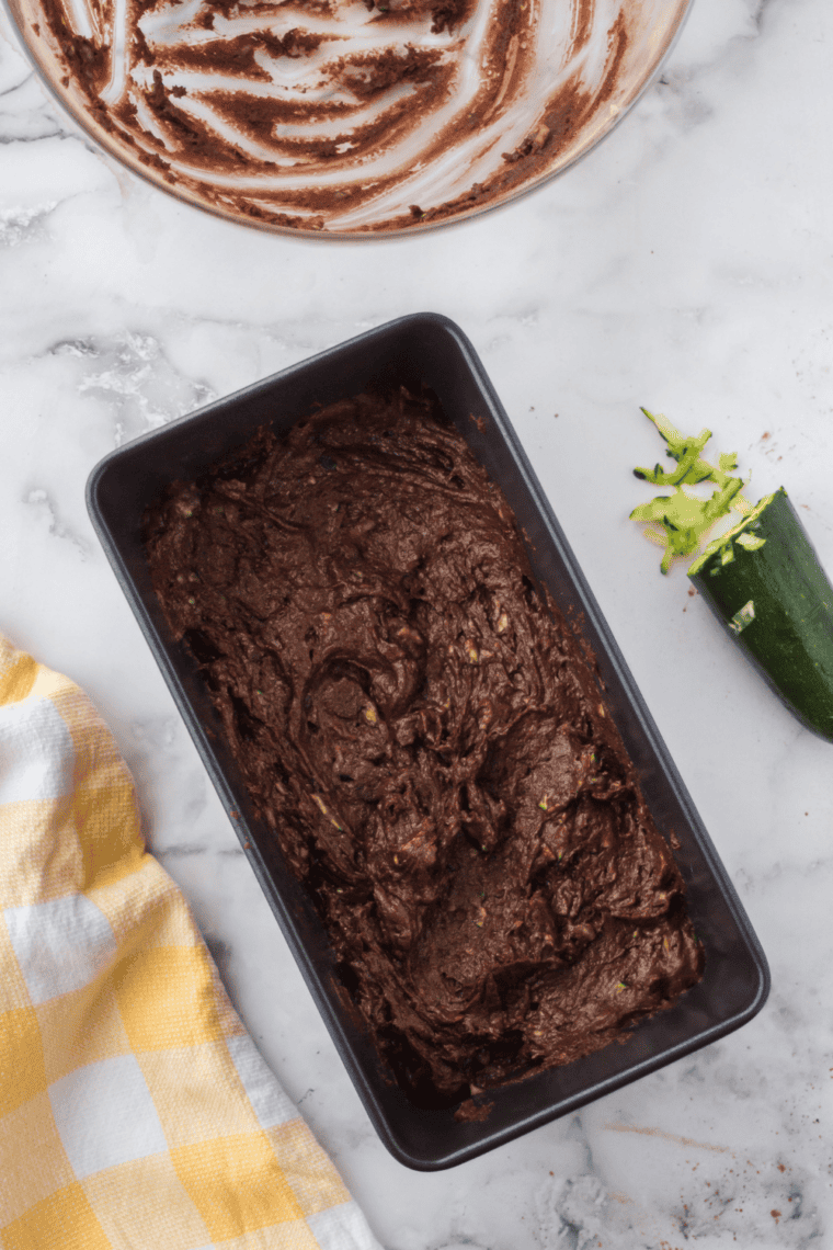 Zucchini bread batter poured into pan, ready to air fry until golden and cooked through.
