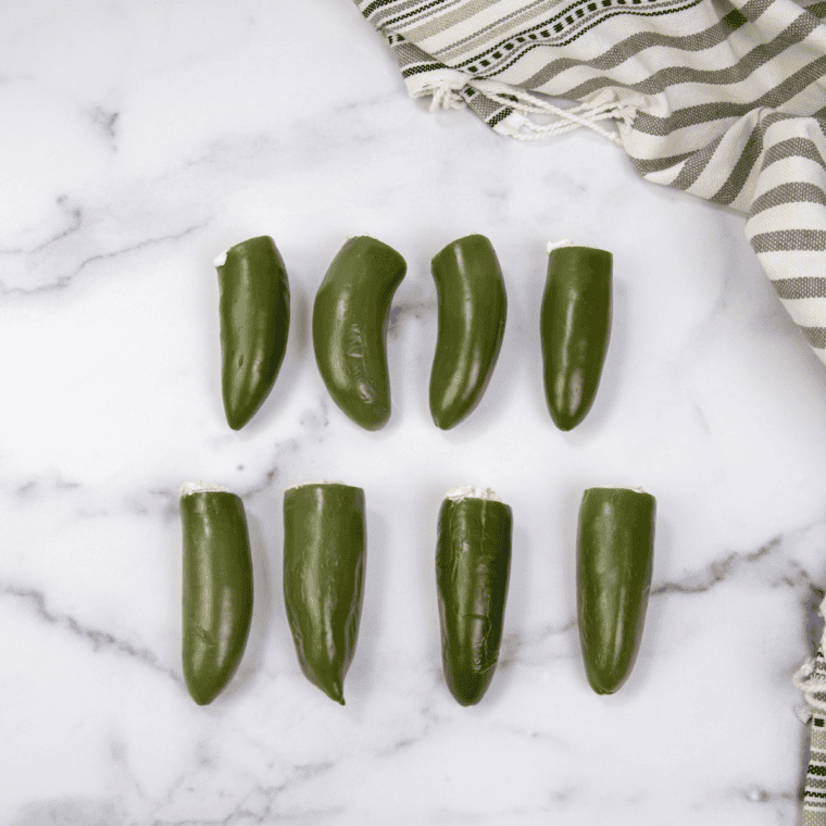 Cream cheese and cheddar mixture in one bowl, ground sausage and beef with seasonings in another bowl.