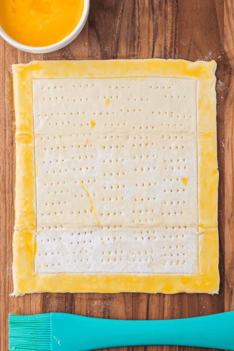 Pastry sheet scored with a border and pricked with a fork.