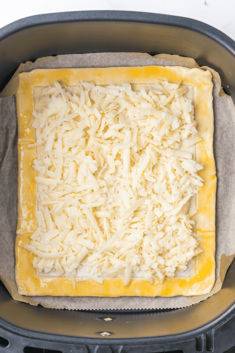 Puff pastry topped with cheese, saut&eacute;ed onions, and asparagus spears.