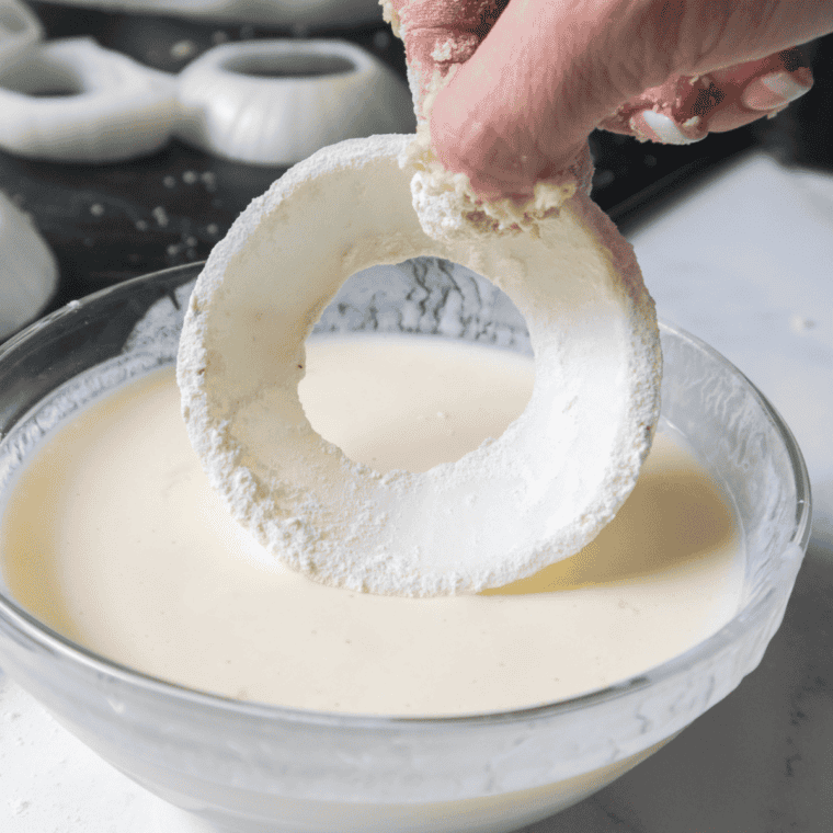 Dip the onion rings into the wet batter then back into the dry batter.