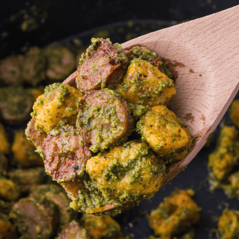 Crispy air fryer sweet potato gnocchi in a white bowl topped with brown butter and fried sage leaves