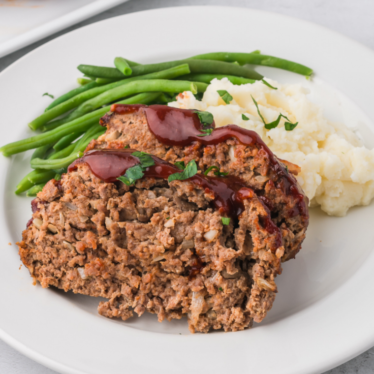 Rustic bowl of mixed meatloaf spices with herbs and seasoning spoon nearby