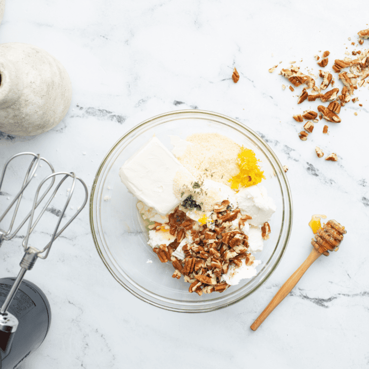 Goat cheese, cream cheese, parmesan, honey, and thyme mixed together in a glass bowl