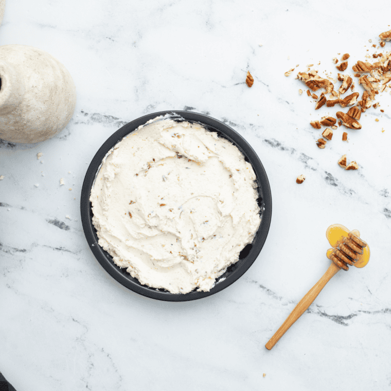 Creamy goat cheese mixture spread evenly into a greased baking dish