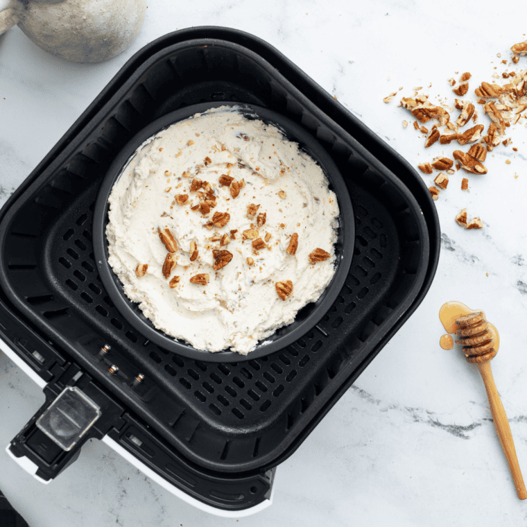Baking dish of goat cheese dip placed in an air fryer basket