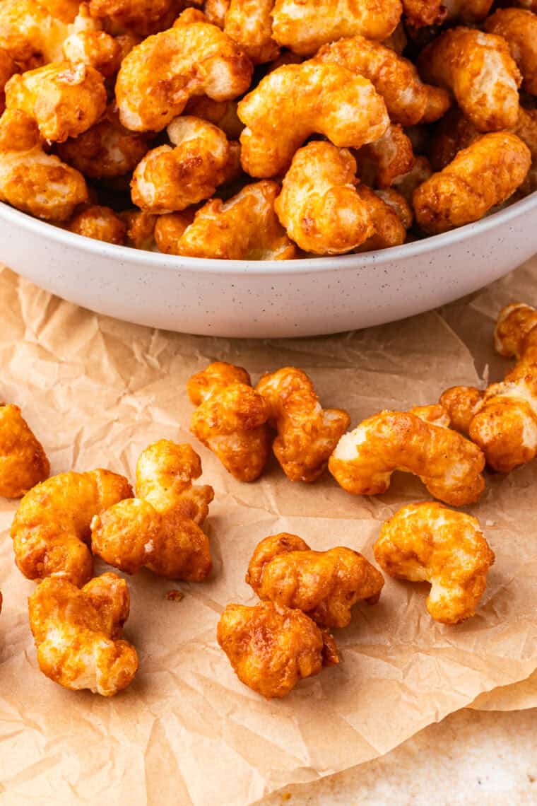 Bowl of homemade copycat Beaver Nuggets with caramel puffed corn scattered beside it