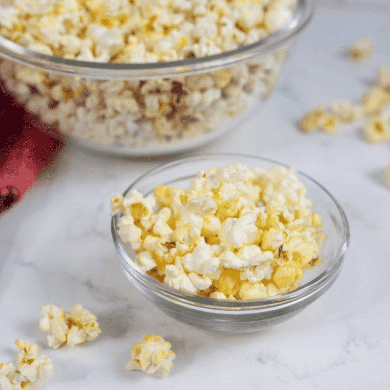 Kettle corn tossed with roasted pecans and peanuts in a wooden bowl for a sweet and salty snack mix