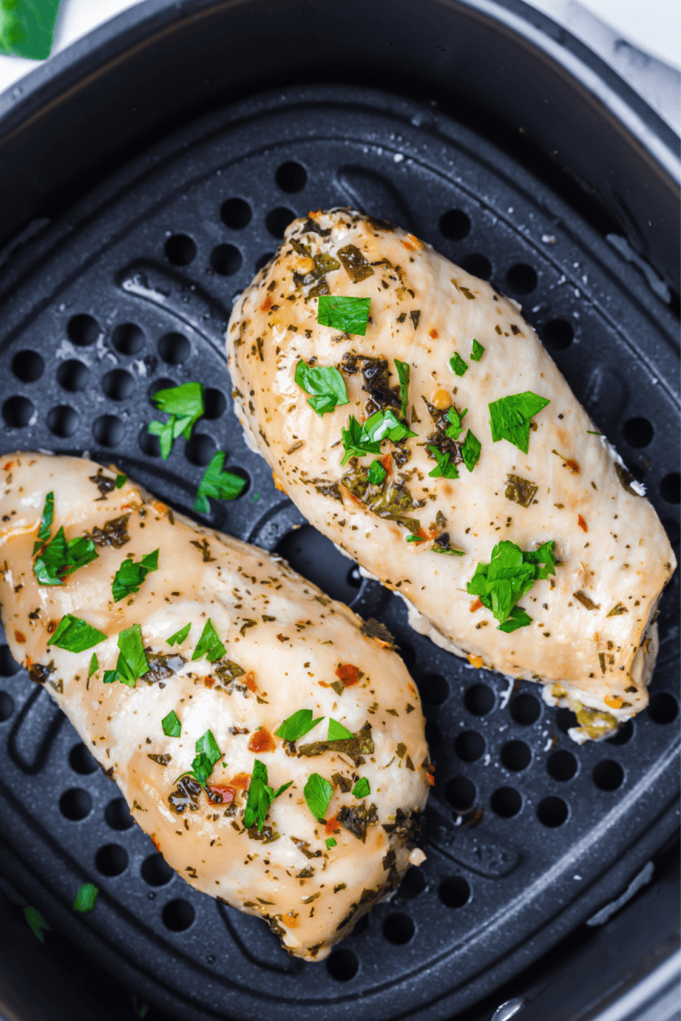Grilled chicken breasts resting on a plate brushed with extra Tuscan herb baste